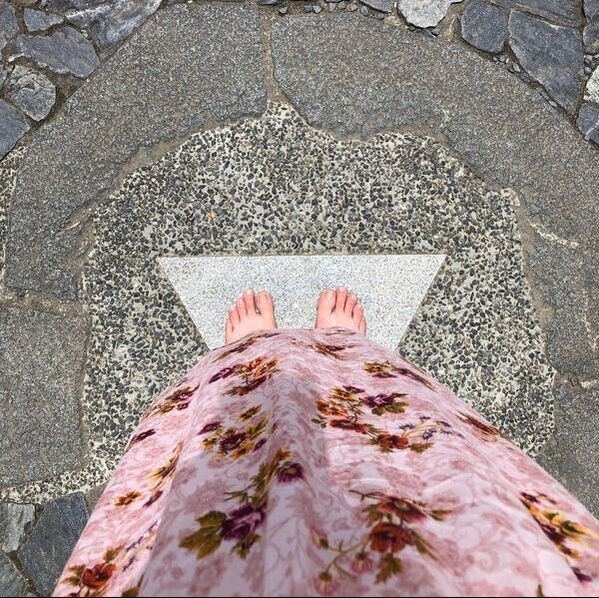 Bare feet resting on a patterned stone path
