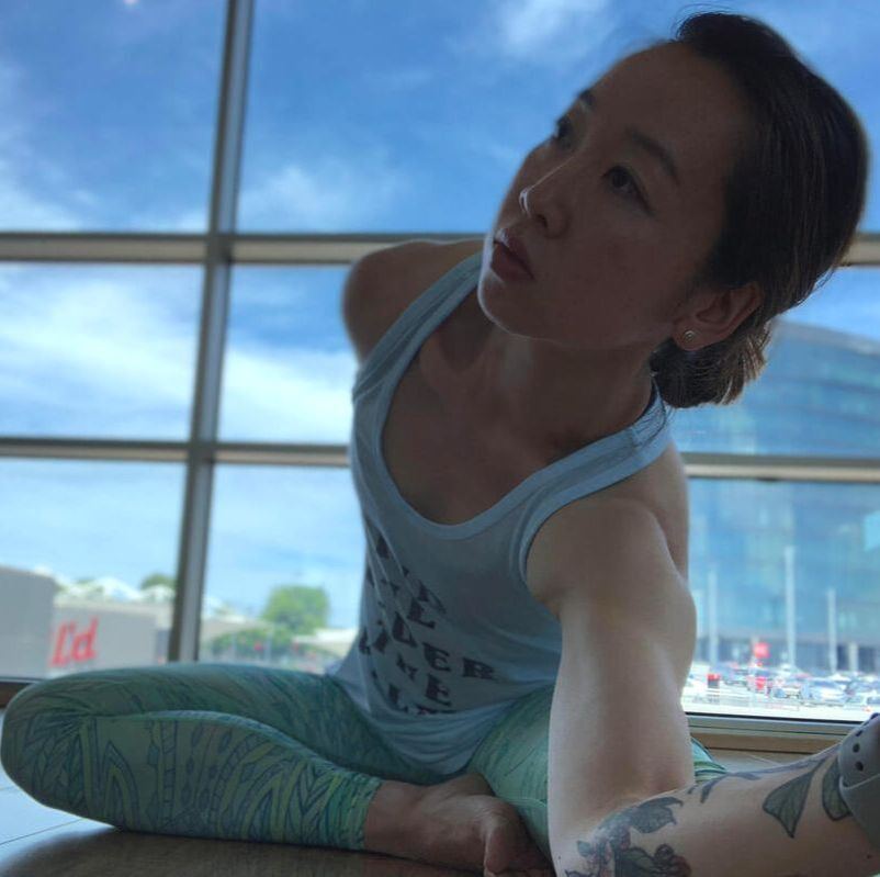 Cass in a seated yoga twist by a sunny window